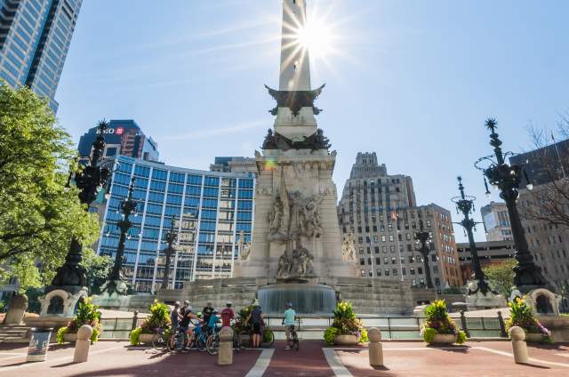 A group touring Monument Circle on bike