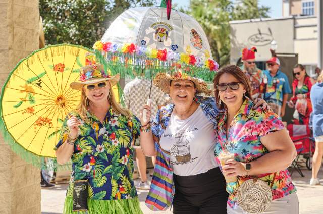 Group of women dressed in tropical clothes with umbrellas