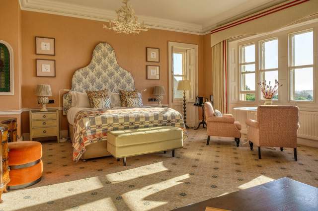 South Lodge Hotel, bedroom with upholstered headboard, light pink walls and bright window