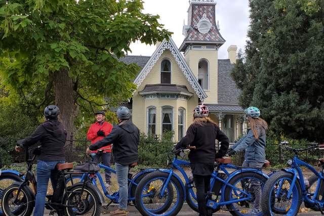 An e-bike tour group stopped at a historic building on West Pearl Street.