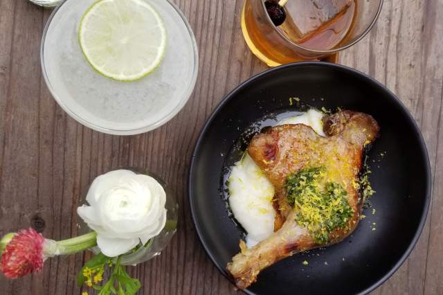 A delicious meal with refreshing drinks and a vase of flowers at Basta in Boulder.