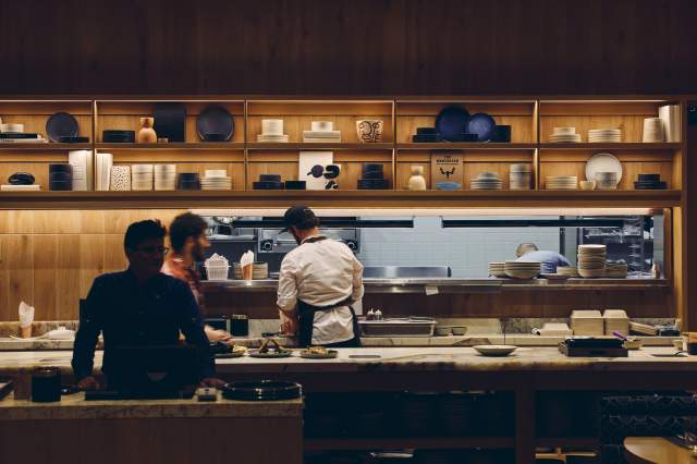 Cooks move around in the kitchen at Ajax Tavern in Limelight Hotel, Boulder.