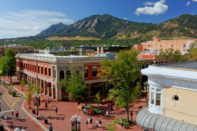 Aerial view of downtown Boulder with the Flatirons in the background
