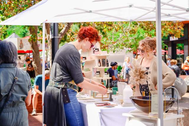 An attendee at Firefly Handmade Festival browses goods at a vendor's booth