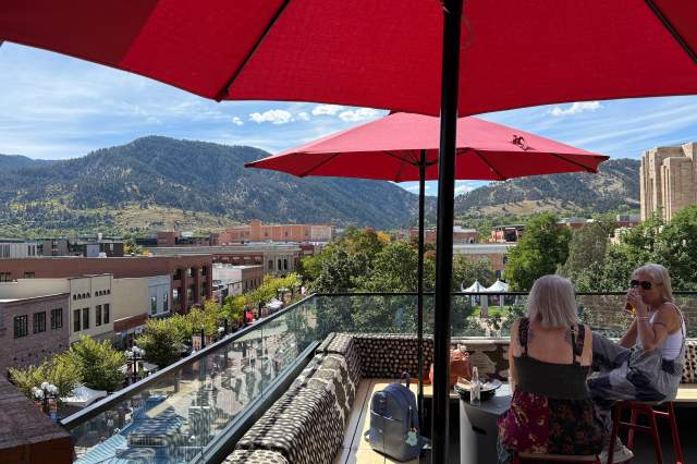 Avanti F&B Rooftop with red umbrellas and view of the foothills