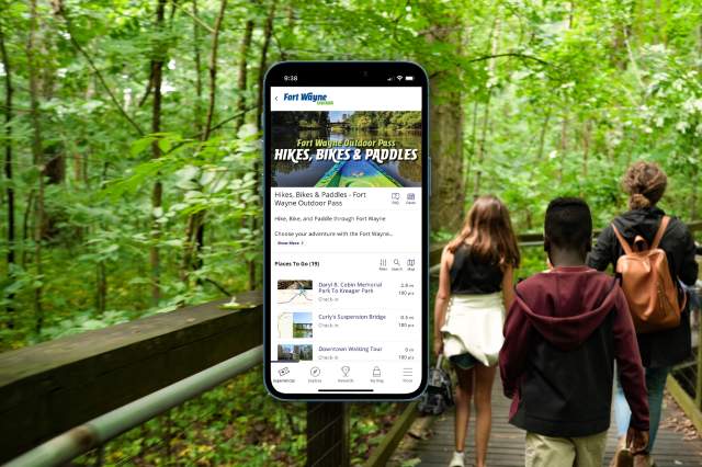 Fort Wayne Outdoor Pass on phone with a family hiking in the background.