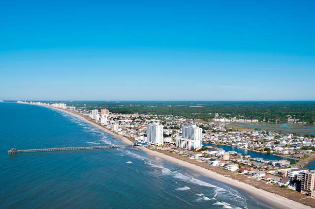 an aerial shot of North Myrtle Beach during a sunny day, featuring the Cherry Grove Pier