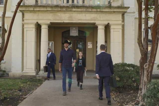 Walker screengrab showing Walker walking out of a white stone courthouse
