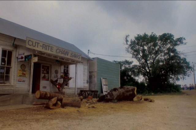 Texas Chainsaw Massacre 2 screengrab, showing the exterior of an old building with a sign reading Cut Rite Chainsaws