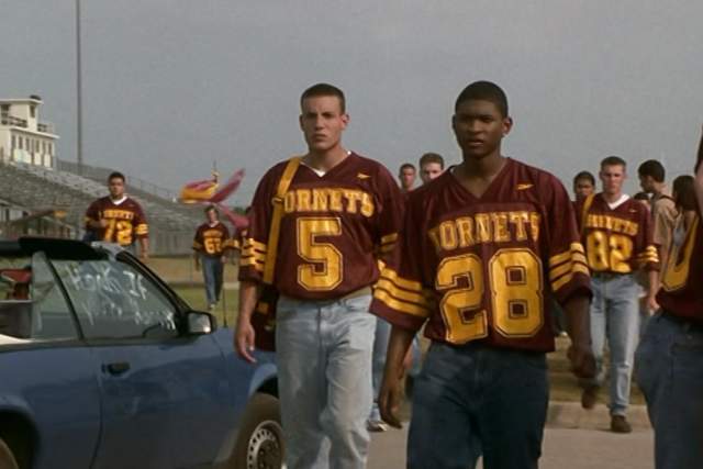 The Faculty screengrab, showing Usher and football players walking away from the Herrington High School Football Field