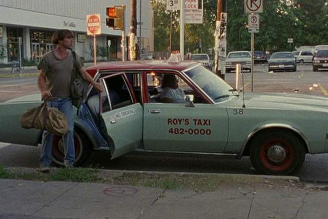 Slacker screengrab showing Richard Linklater getting out of a blue taxi that reads Roy's Taxis