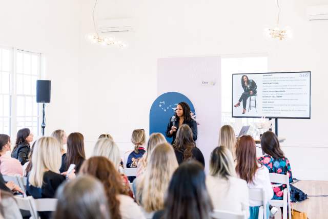 Woman speaking in front of a crowd for a conference session.