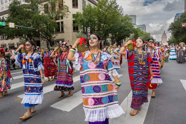 Image of people walking down Congress Avenue in the Viva la Vida festival.