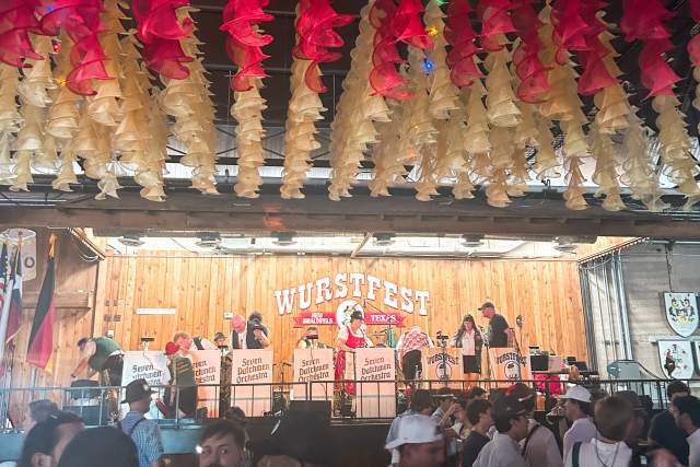 The wood-paneled stage at Wurstfest with colorful streamers hanging from the ceiling.