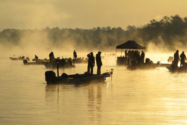 Fishermen competing in the Bass Masters tournament line up on their boats during a foggy morning on Lay Lake.