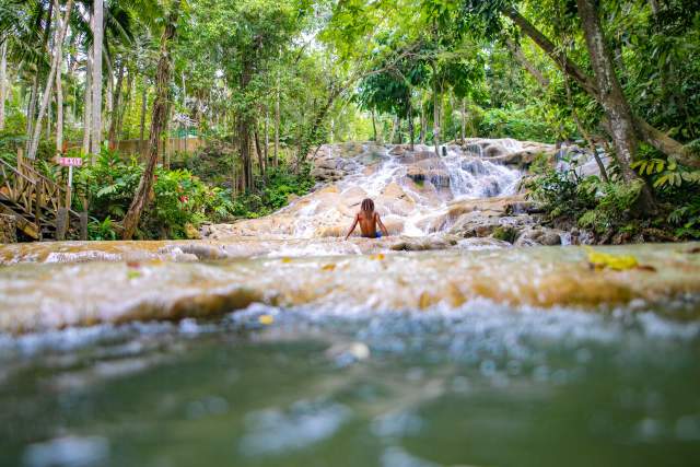 Image of man sitting on the falls at Dunn's River Falls