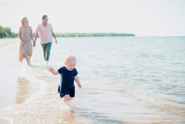 A family strolls down a calm Keweenaw beach