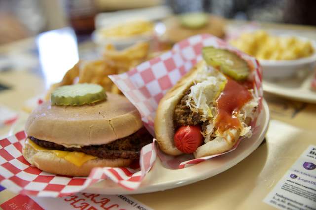 Plate with cheeseburger and hot dog with relish and ketchup