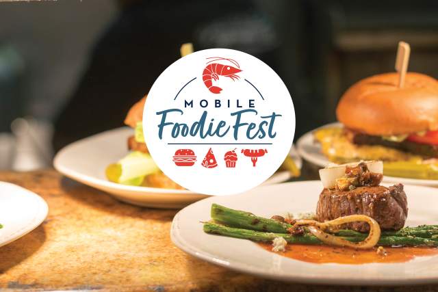 Mobile Foodie Fest logo (white circle with blue text and red icons of a shrimp, a burger, a pizza slice, a cupcake and a sausage on the end of a fork) with burgers and steak bites in the background