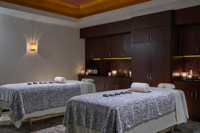 two massage beds with hot rocks in a dimly lit room