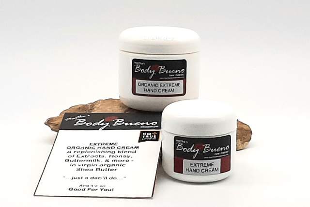 two containers of organic hand cream sit on a flat brown rock in front of a white background. A small placard in front of them reads "Extreme Organic Hand Cream: A refreshing blend of extracts, honey, buttermilk and more - in virgin organic shea butter. A dab will do, and it will be good for you!"