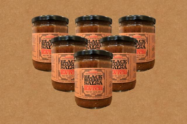 Six jars of Black Market Salsa are arranged in a group on a brown background. Each jar has an orange label with black and red text.