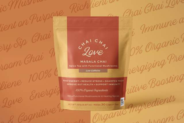 Product package of Chai Chai Love Masala Chai displayed against a patterned background. The package mentions the tea contains functional mushrooms, spices, and offers health benefits like energy boost and improved focus.