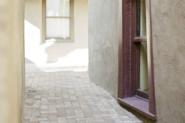 Drench: A ray of afternoon sunlight soaks this alleyway in Albuquerque Old Town in a warm glow.