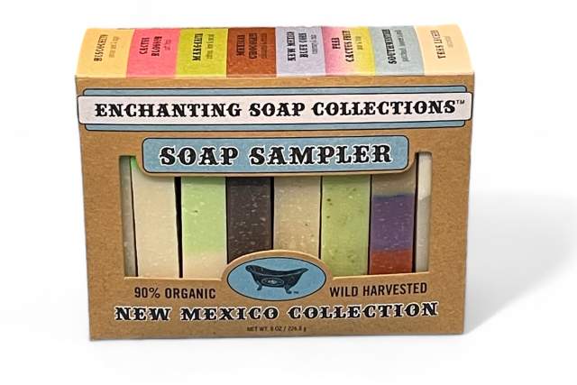 A box labeled "Enchanting Soap Collections - Soap Sampler 90% Organic Wild Harvested New Mexico Collection," containing four different colored bars of soap.