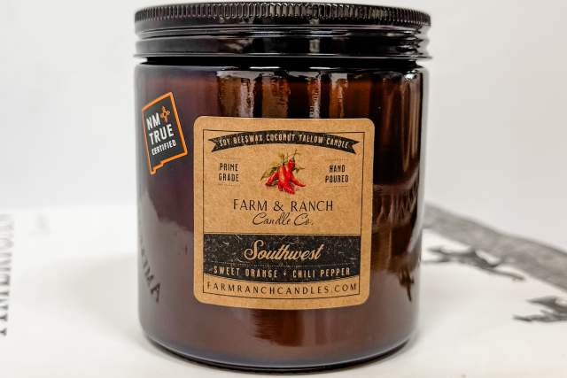 A jar of Farm & Ranch Candle Co. sweet orange chili pepper scented candle.