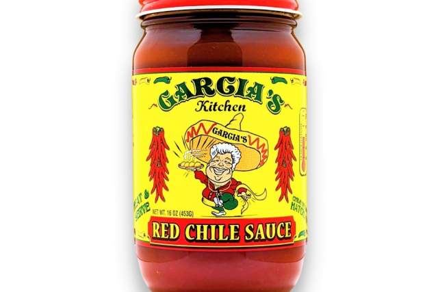 A jar of Garcia's Kitchen Red Chile Sauce with a bright yellow label featuring a cartoon character wearing a sombrero. The label includes red chile peppers and the text "Garcia's Kitchen" and "Red Chile Sauce" in bold letters.