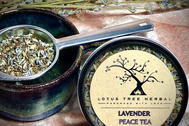 Dried lavender peace tea from Lotus Tree Herbal, displayed alongside lavender sprigs and a ceramic bowl with a spoonful of tea leaves.