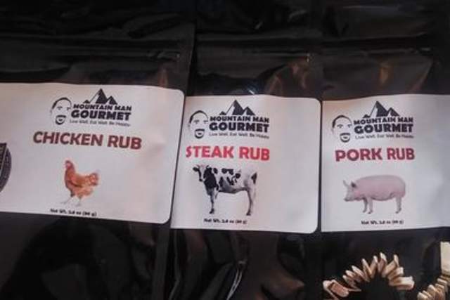 Three packages of Mountain Man Gourmet seasonings, labeled Chicken Rub, Steak Rub, and Pork Rub, displayed on a countertop.