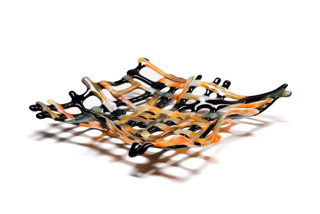 Decorative glass bowl with an intricate splash design, featuring black, orange, and white swirls, displayed on a white background.
