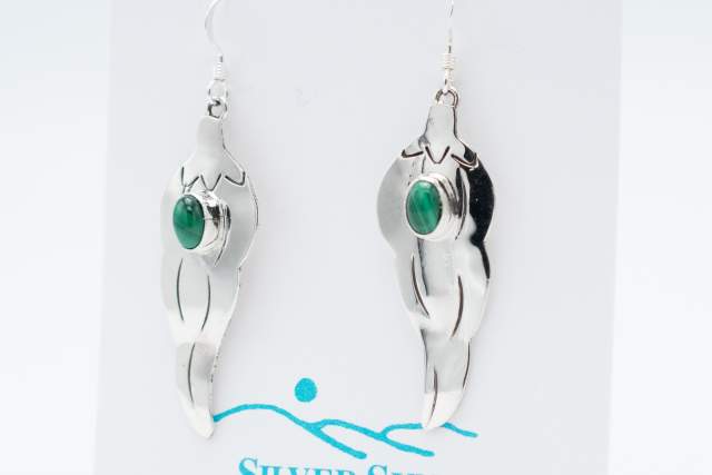 Silver earrings with green stones displayed on a card labeled "Silver Sun Native American Handmade.