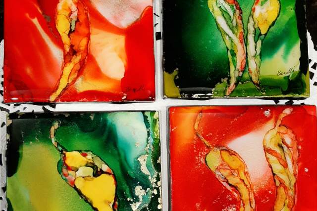 Four abstract glass coasters depicting red and green chiles