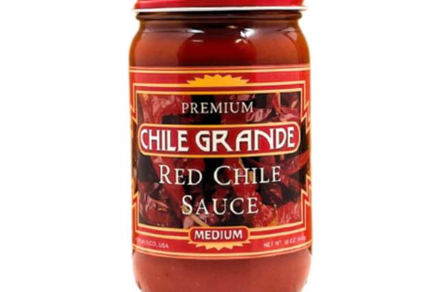 A jar of Chile Grande Red Chile Sauce, labeled as medium spiciness, isolated on a white background.