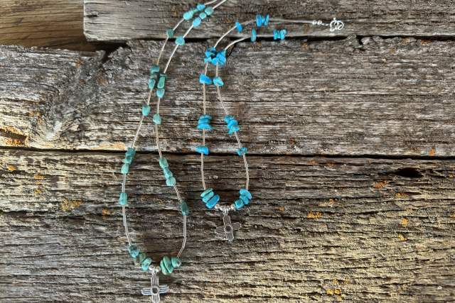 Turquoise bead necklace and earrings displayed on a weathered wooden background.