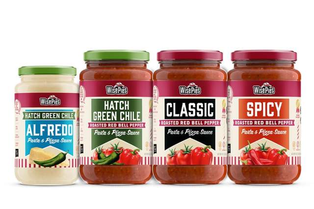 Four jars of WisePies pizza and pasta sauces, labeled from left to right as Hatch Green Chile Alfredo, Hatch Green Chile Roasted Red Bell Pepper, Classic, and Spicy Roasted Red Bell Pepper.