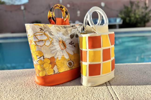 yellow and orange patterned bags sit on a pool deck in front of a blue pool with an adobe wall in the background