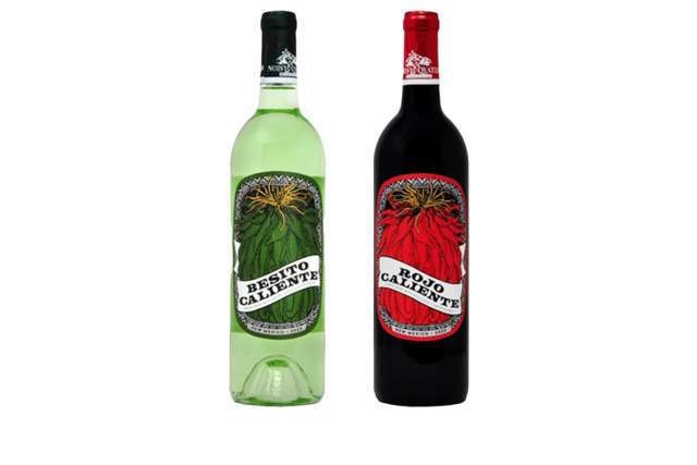 Two bottles of Wine, one labeled "Besito Caliente" in a green bottle and the other labeled "Rojo Caliente" in a red bottle, displayed against a white background.