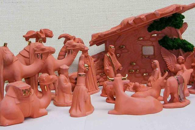 A collection of terracotta figurines depicting a Nativity scene, including various human figures, animals, and a stable.