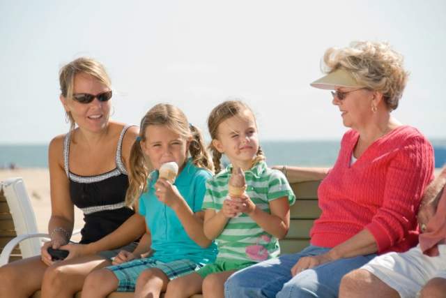 family on boardwalk bench eating ice cream
