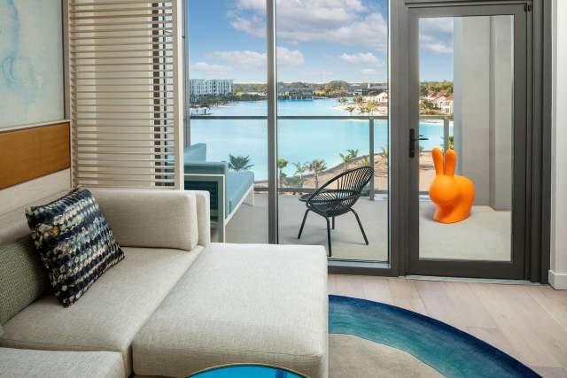 Room with king bed and balcony view of lagoon at Conrad Orlando