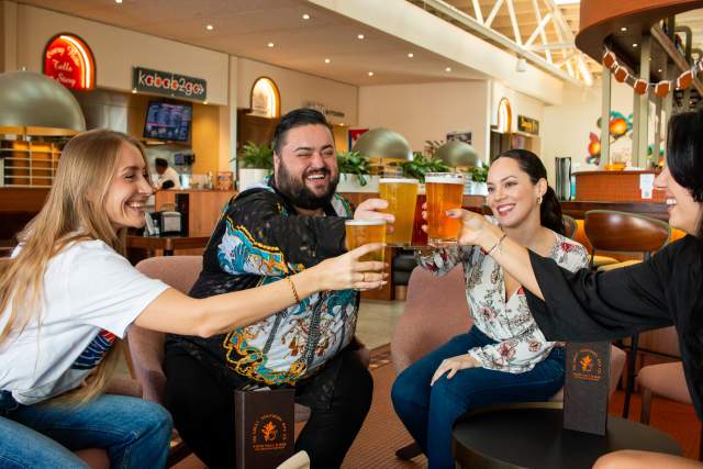 Group toasting drinks in food hall at Great Southern Box Food Hall & Bar