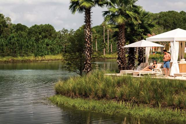 a couple relaxing by the water at the Four Seasons Resort Orlando