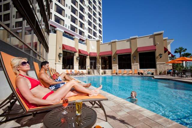 A family relaxes poolside at Ramada Plaza Resort & Suites International Drive in Orlando.