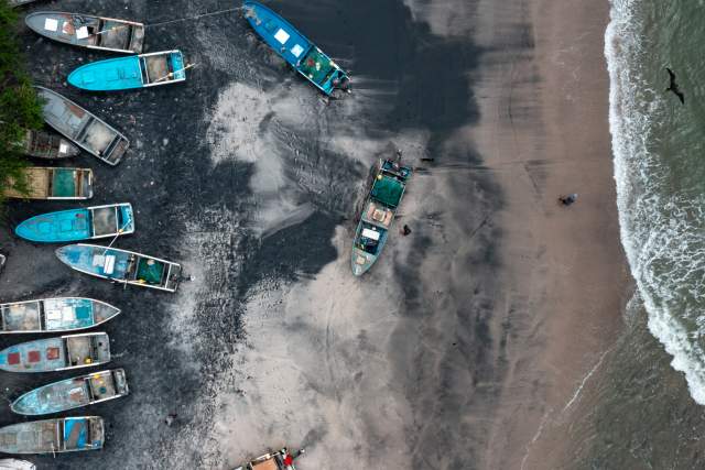 View of black sand of Gorgona beach, fishing boats