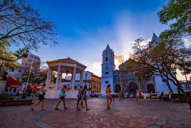 Sunset behind the Metropolitan Basilica Cathedral Santa Maria La Antigua and Plaza Catedral (Independence Square) filled with visitors (side view)