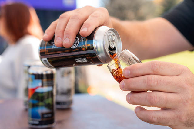 Hand pouring a hand of beer into a glass